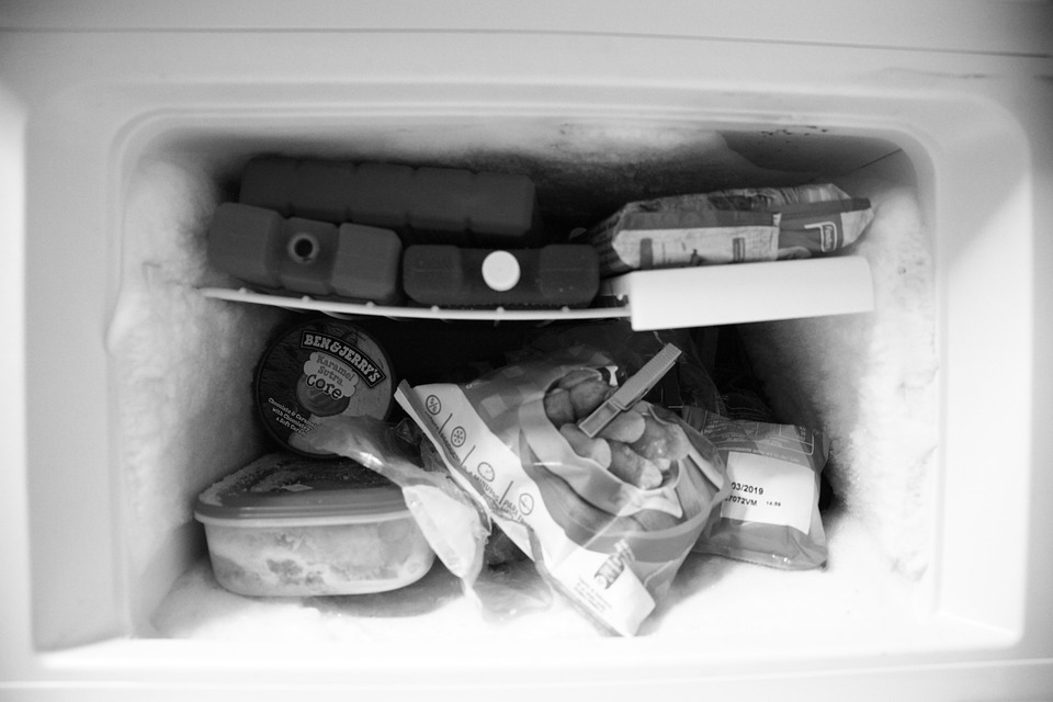 Black and white image of an overstuffed home freezer