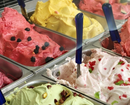 Image of a variety of ice cream flavors in a commercial freezer case.